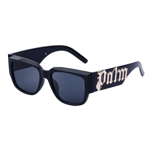 Lunettes de soleil yeux de chat noires avec logo Palm doré sur les branches larges