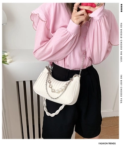 Détail du sac croissant plissé blanc avec décor perles et chaîne florale argentée