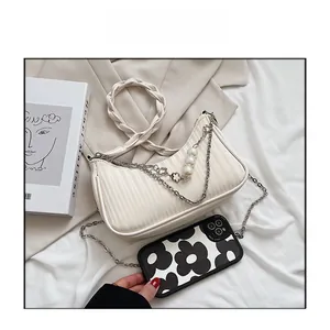 Détail du sac à bandoulière plissé blanc cassé avec chaîne à perles et anse tissée
