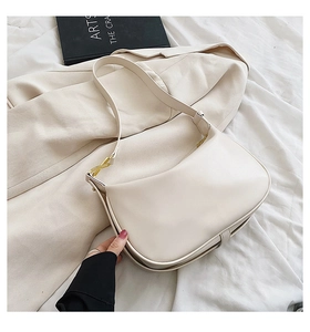 Vue détaillée du sac à bandoulière en cuir crème avec des boucles dorées élégantes