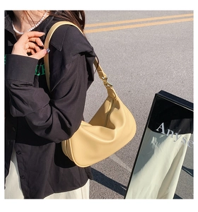 Sac hobo chic jaune crème porté par une personne pour un look d'été moderne et décontracté