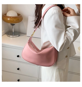 Sac sous le bras croissant rose avec cuir plissé et détails dorés porté à l'épaule