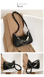 Détail du sac hobo noir avec plis verticaux, bandoulière tressée et décor en perles