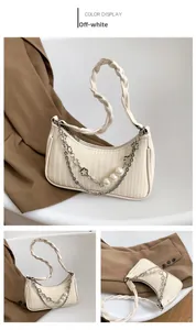Détail macro du sac beige avec surpiqûres verticales et poignée tressée