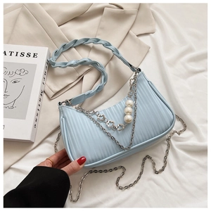 Gros plan sur un sac à main plissé bleu clair avec perles et chaîne en métal fleuri