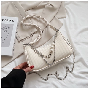 Détail du sac à bandoulière plissé beige avec breloque perle et anse tressée