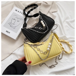 Détail de sacs plissés avec poignées tressées et accents de chaîne fleur perlée