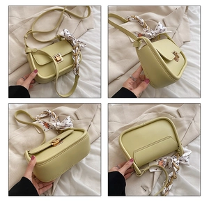 Detail view of avocado green crossbody bag featuring gold metal twist lock and silk scarf