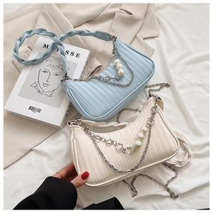 Détail de sacs bandoulière croissants froncés en bleu clair et beige avec chaîne
