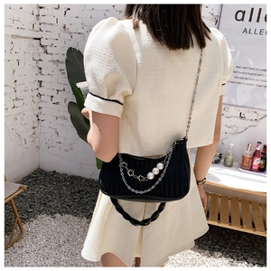 Détail du sac plissé noir en similicuir avec perles élégantes et bandoulière en chaîne argent