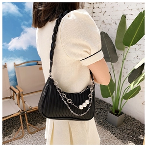 Détail du sac sous l'aisselle plissé noir avec chaîne argentée et accents de perles