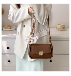 Chic brown leather shoulder bag with a decorative silk scarf and gold lock detail
