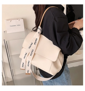 Detail of off-white crossbody bag with stylish lettered wide strap for daily commute