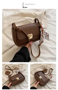 Brown leather crossbody bag detail with gold metal lock and silk scarf wrapped handle