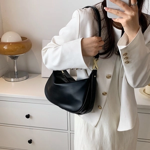 Sac bandoulière minimaliste en cuir noir mat avec élégants détails en métal doré chic