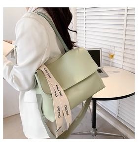 Detail of light green tote bag with wide 'Chia'2nd' printed strap for shoulder wear