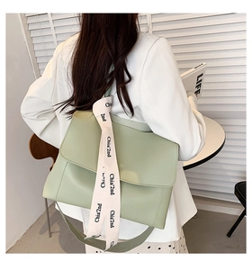 Close-up of light green PU leather messenger bag with woven 'Chia'2nd' shoulder strap