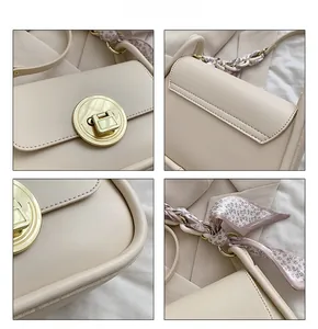 Close-up of cream leather shoulder bag with golden twist lock and floral scarf handle