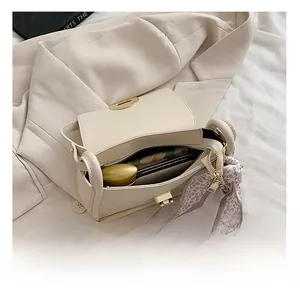 Top view of cream leather flap bag interior capacity with decorative floral scarf