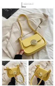 Detail of yellow baguette bag showing the round metal buckle and magnetic snap closure