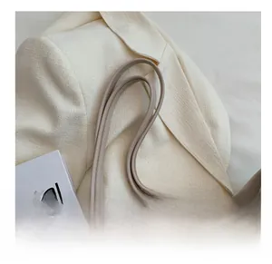 Détail des longues bandoulières confortables d'un sac cabas minimaliste beige femme
