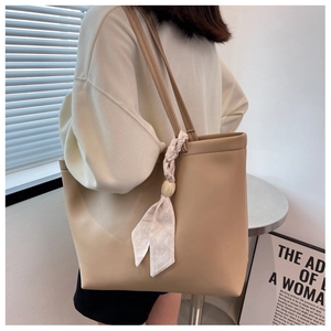 Grand sac cabas beige avec détail chic de foulard en soie géométrique porté à l'épaule