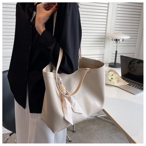 Détail du grand sac cabas crème avec un élégant foulard fleuri attaché sur le côté