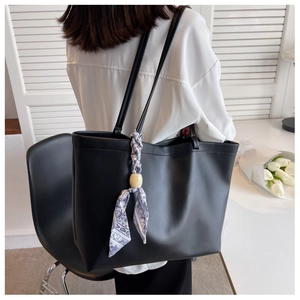 Détail d'un sac cabas en cuir PU noir avec foulard en soie imprimé et perle en bois