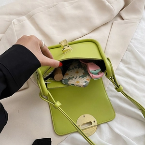 Neon green faux leather crossbody bag with gold twist lock and organized interior