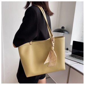 Sac fourre-tout jaune avec détail de foulard en soie sur la bandoulière dans un bureau
