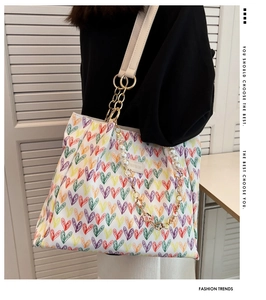 Détail du sac cabas blanc à cœurs colorés avec anse en perles et étiquette mode