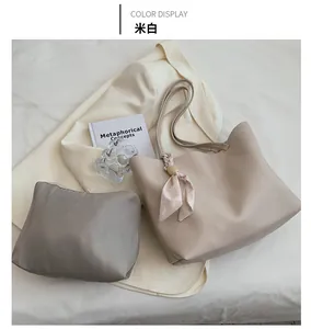 Vue de dessus d'un sac cabas crème avec foulard au manche et pochette tissée