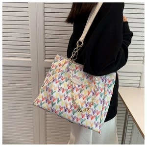Détail du sac cabas à motifs cœurs avec poignée en perles et étiquette mode