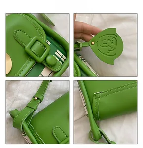 Detail view of green PU leather shoulder bag with plaid pattern and cat charm accessory