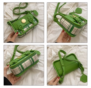 Detail view of a green and beige checkered crossbody bag with leaf pendant and metal clasp
