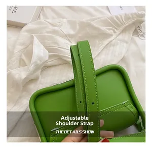 Detail of adjustable shoulder strap and precise stitching on green leather crossbody bag