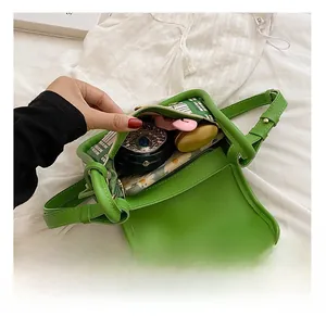 Interior view showing storage capacity of green PU leather crossbody bag with items