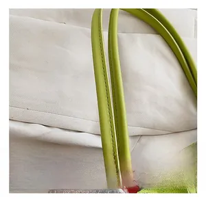 Gros plan d'un sac à main vert avocat en cuir grainé avec détails de coutures doubles