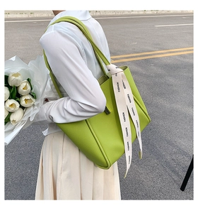 Détail du sac cabas vert avocat avec texture grainée et ruban de mode élégant