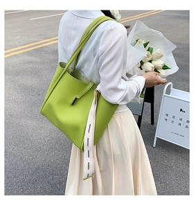 Détail du sac cabas vert avocat avec texture litchi et ruban mode en décor extérieur