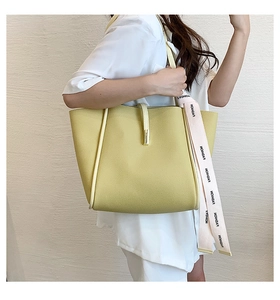 Détail d'un cabas en cuir jaune vif orné d'un foulard rose imprimé tendance