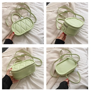 Detail view of mint green quilted handbag with wavy stitching and marble zipper charm