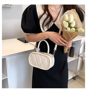 Detail of cream quilted PU leather handbag with elegant top handle and crossbody strap