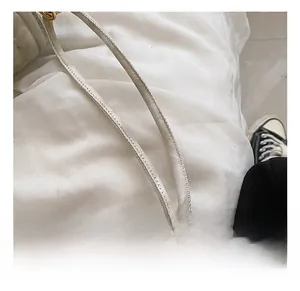 Detail of cream white leather handle featuring reinforced stitching and textured finish