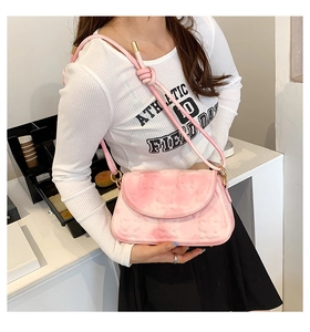 Detailed close-up of pink cloud texture embossed bag with knotted shoulder strap and buckle