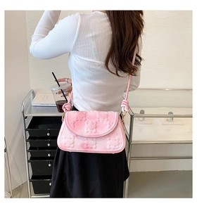 Close-up of pink gradient shoulder bag with 3D bear relief on a model in home setting