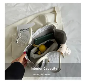 Top view of large capacity tote bag interior holding umbrella, phone, and makeup