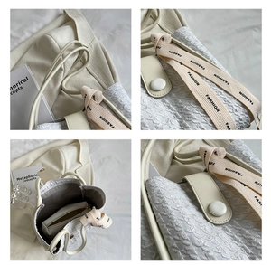 Detail view of cream white pleated tote bag with fashion ribbon and inner pouch