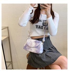 Detail view of purple tie-dye shoulder bag with embossed texture and gradient rope strap
