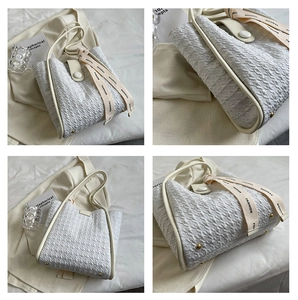 Detail view of white bubble texture tote bag with cream leather handles and bottom studs